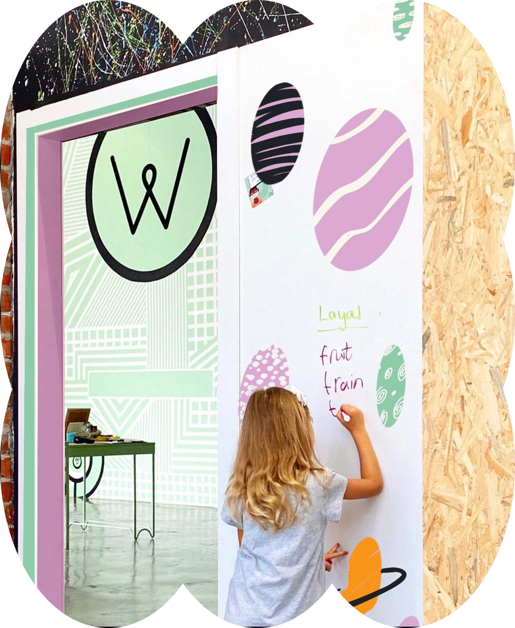 A Wisdom Warehouse student writing on a classroom wall